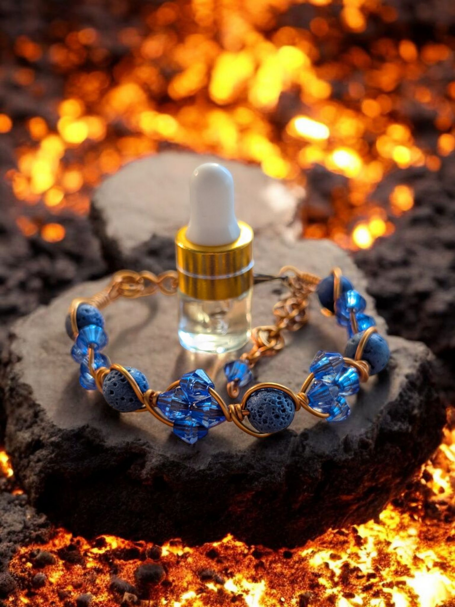 Handcrafted adjustable cuff diffuser bracelet with blue lava beads and blue resin bicone accents wrapped in copper hypoallergenic wire, displayed on a rock above glowing lava. part of the Ignite Series collection.